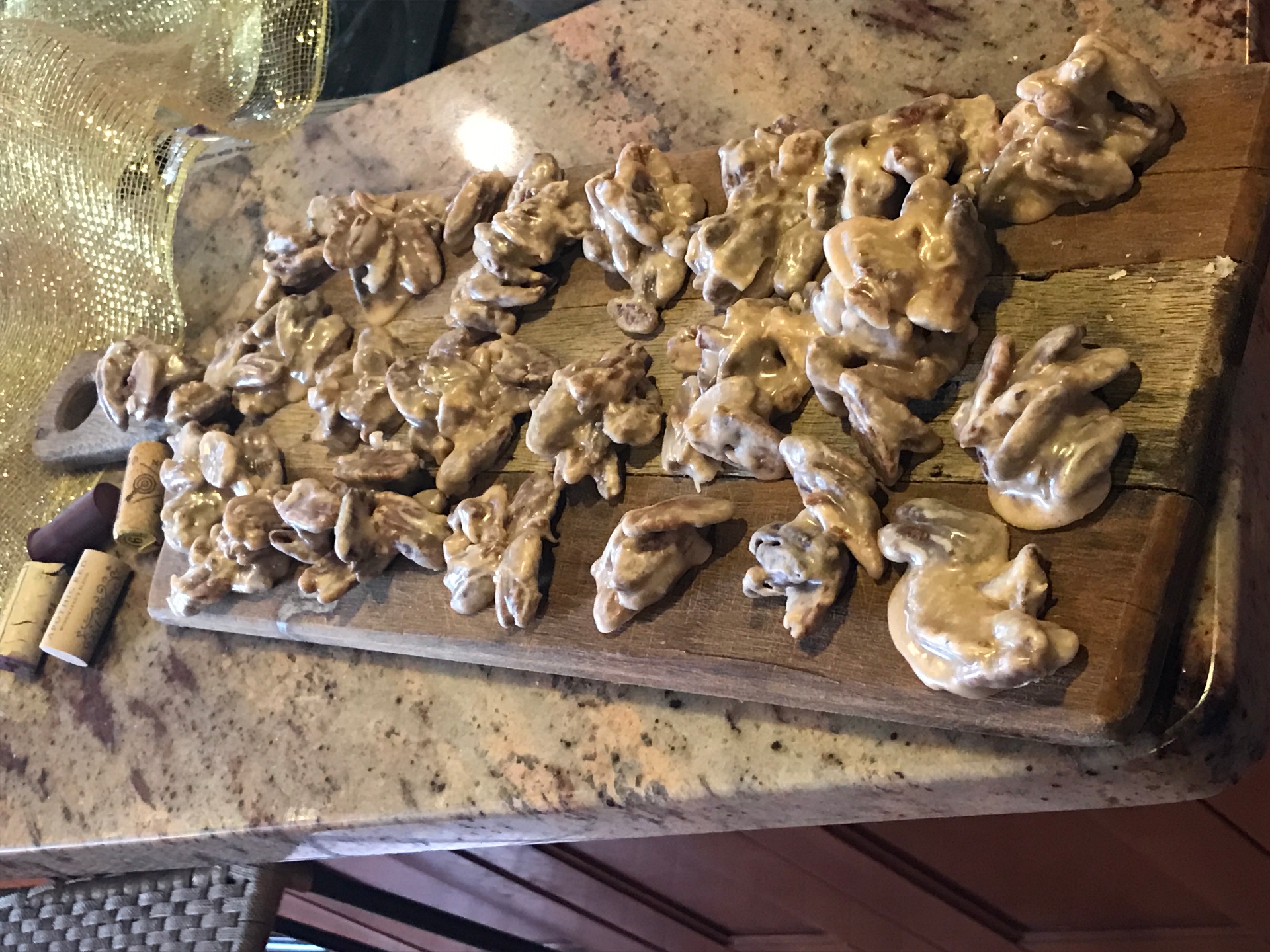 Golden homemade pecan pralines cooling on a wooden board